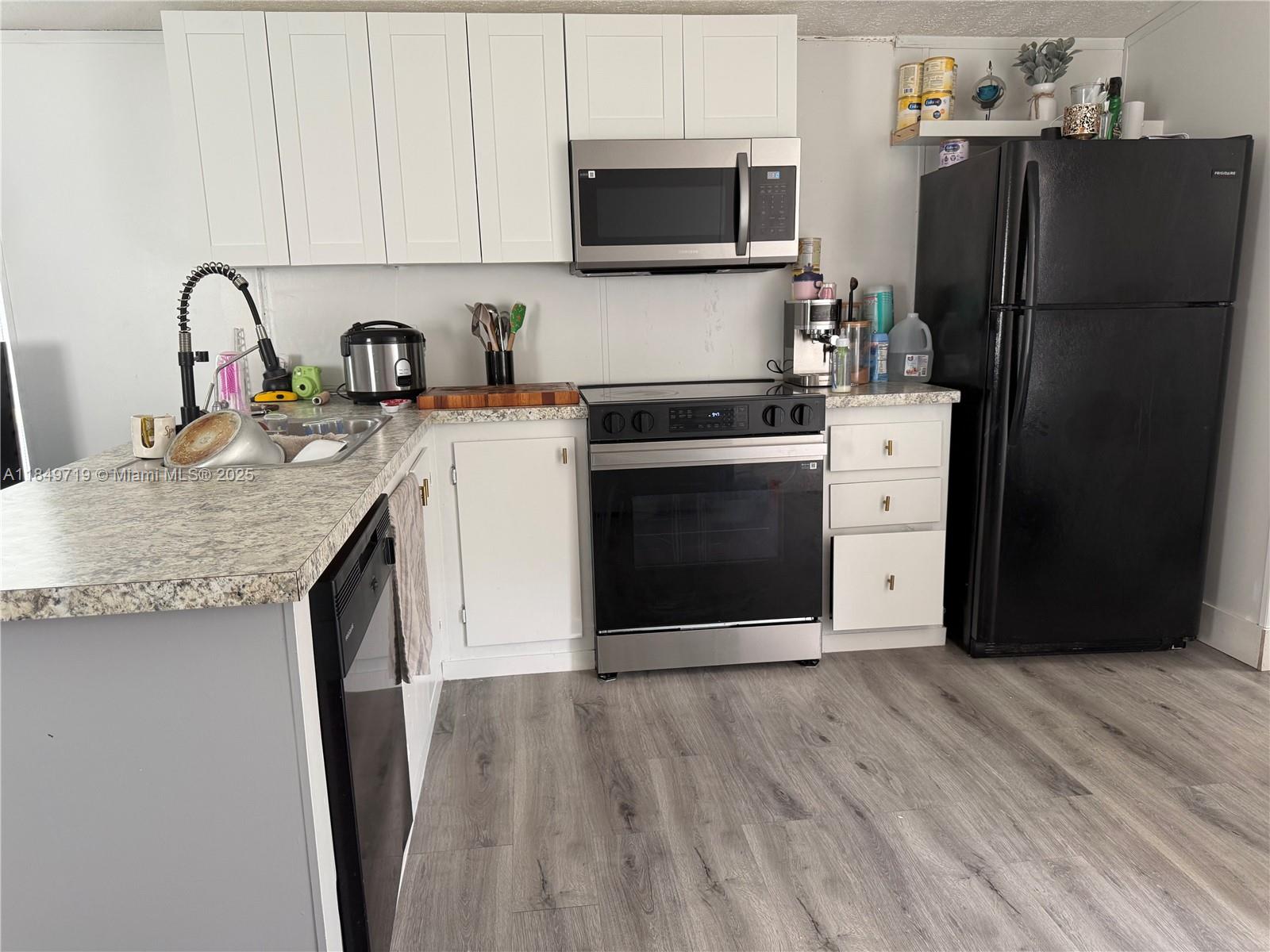 830 South Kennel Street Clewiston, FL 33440 - Photo 6 of 30 a kitchen with a refrigerator sink and cabinets
