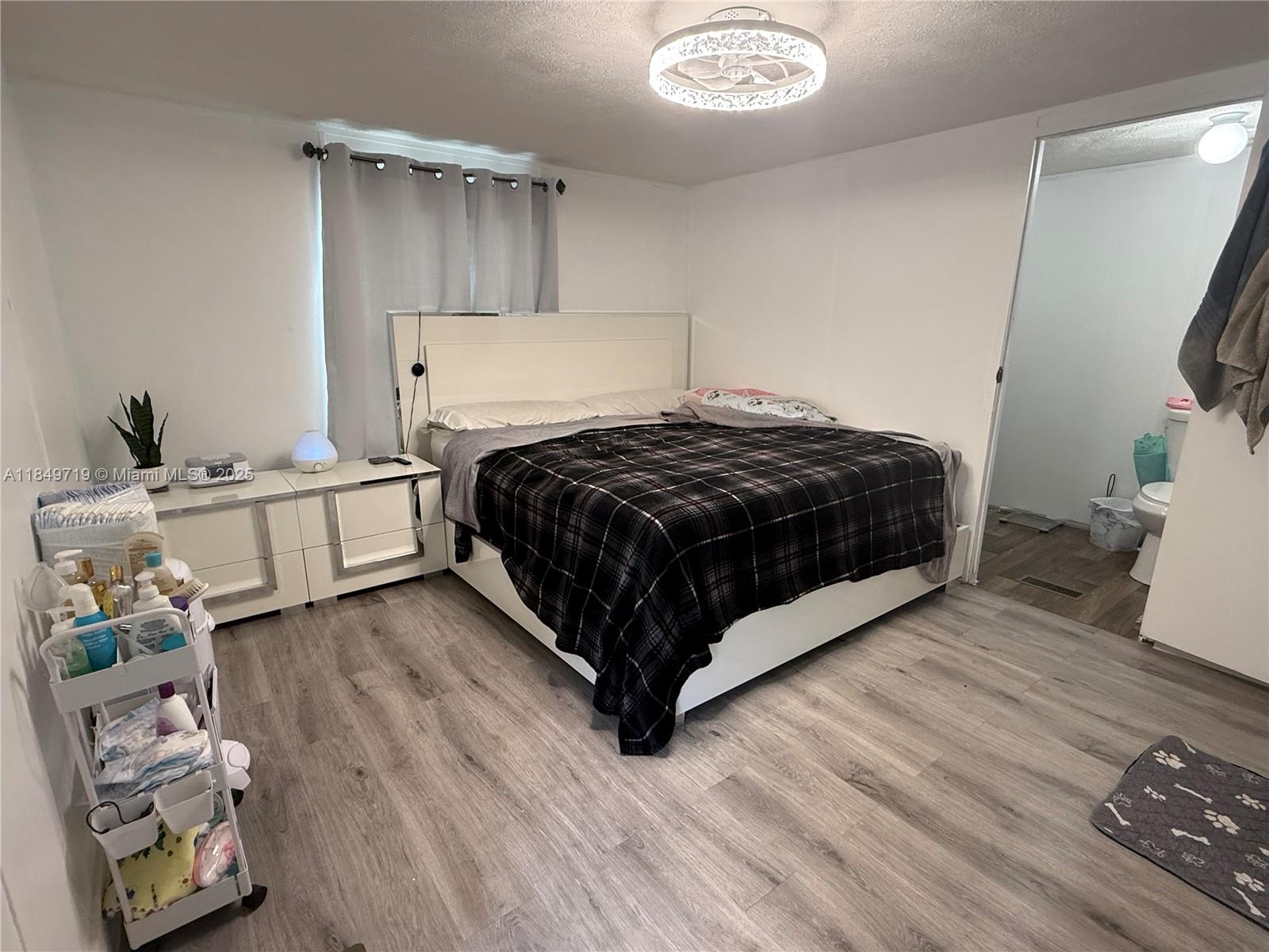 830 South Kennel Street Clewiston, FL 33440 - Photo 8 of 30 a bedroom with a bed and a dresser