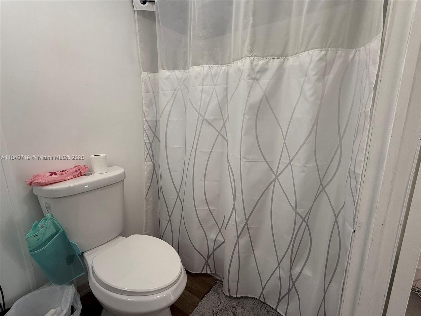 830 South Kennel Street Clewiston, FL 33440 - Photo 10 of 30 a white toilet sitting next to a shower curtain