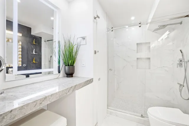 a bathroom with a sink a toilet and shower