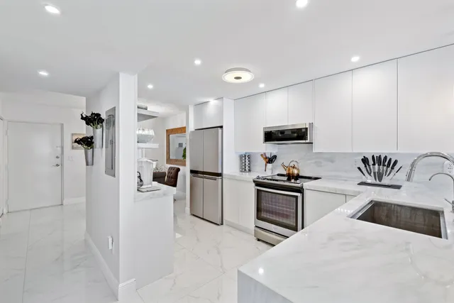 a kitchen with stainless steel appliances granite countertop a refrigerator stove microwave and sink