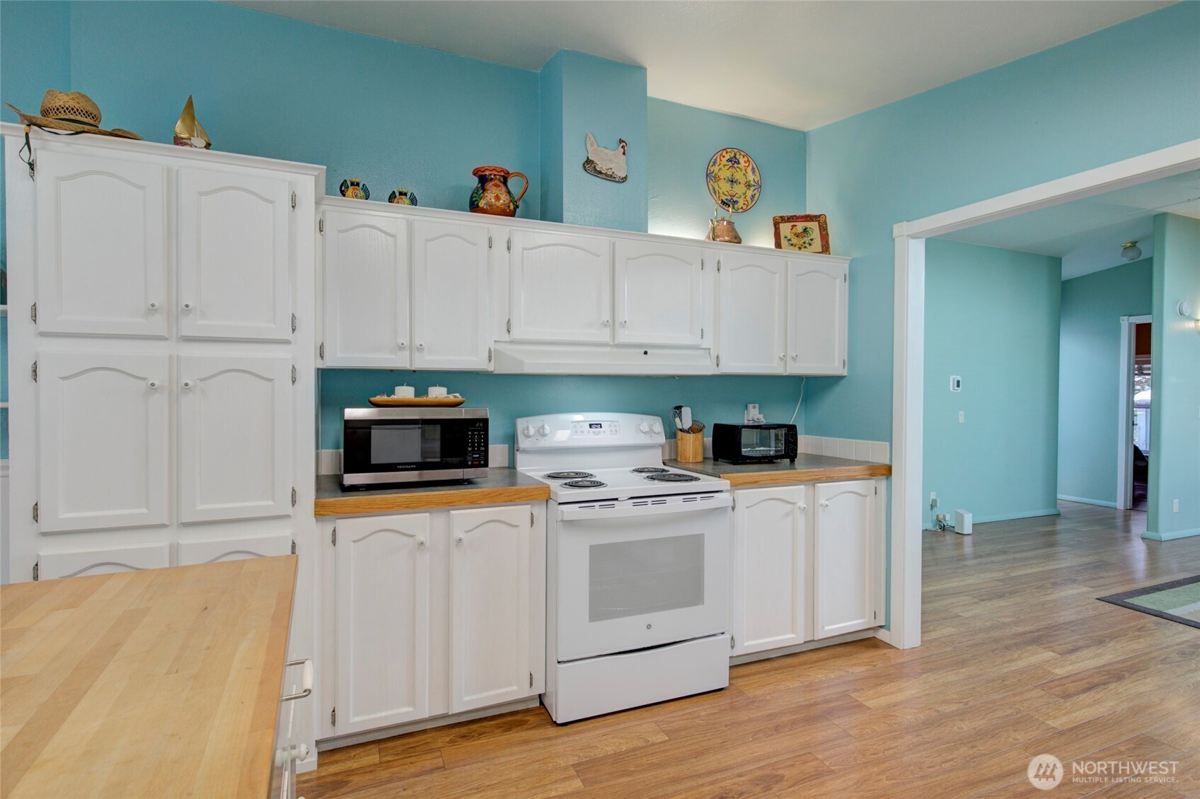 1362 Oceano Drive Grayland, WA 98547 - Photo 7 of 35 a kitchen with stainless steel appliances white cabinets and wooden floor