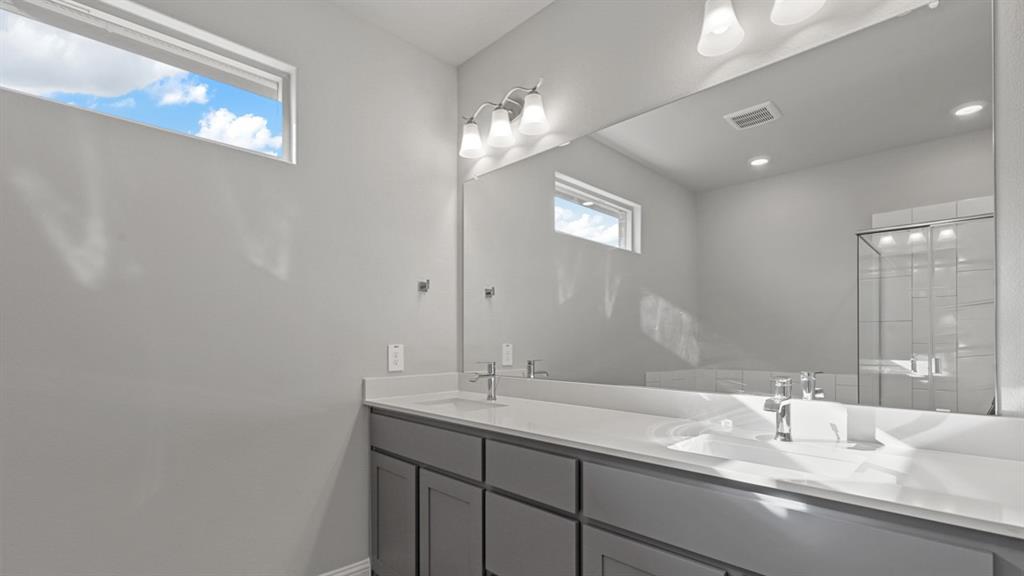 11209 Treehouse Trail Justin, TX 76247 - Photo 18 of 40 a bathroom with a double vanity sink and a mirror
