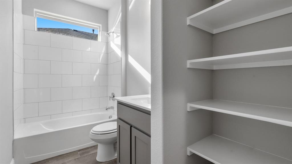 11209 Treehouse Trail Justin, TX 76247 - Photo 31 of 40 a bathroom with a toilet a sink and bathtub