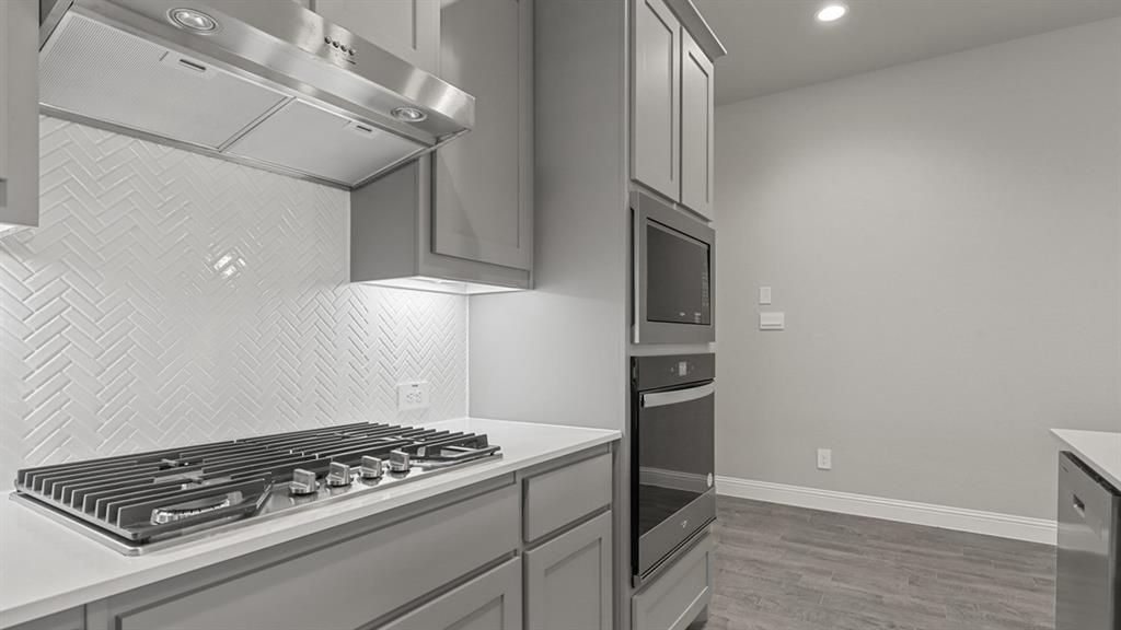 11209 Treehouse Trail Justin, TX 76247 - Photo 3 of 40 a kitchen with stainless steel appliances granite countertop a stove and a refrigerator