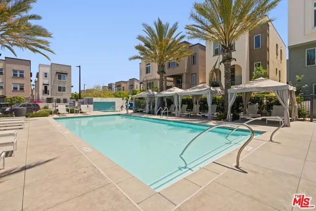 a view of a swimming pool with a lawn chairs under an umbrella