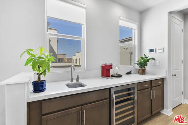 a kitchen with stainless steel appliances granite countertop a refrigerator a stove and a sink with wooden floor