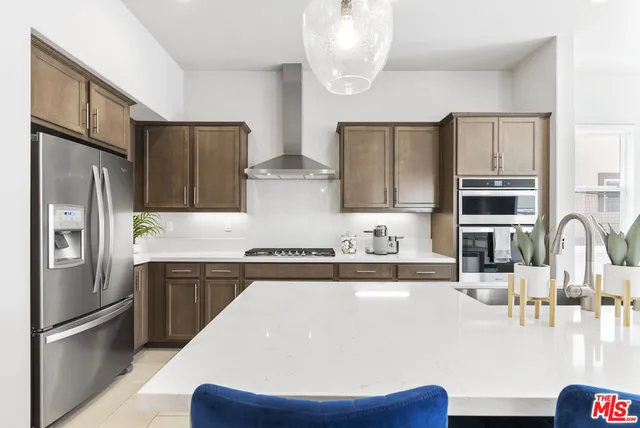 a kitchen with stainless steel appliances a sink stove and refrigerator