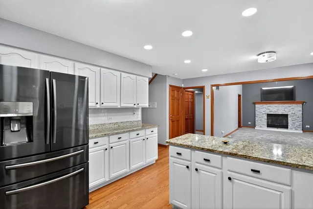 a kitchen with granite countertop white cabinets and stainless steel appliances