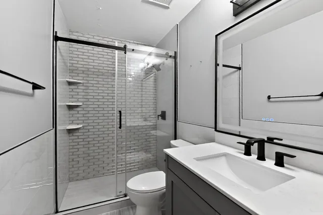a bathroom with a sink toilet and shower