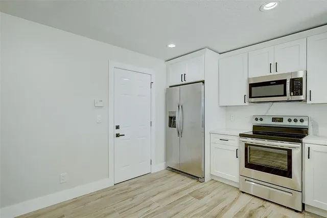 a kitchen with a refrigerator stove and microwave