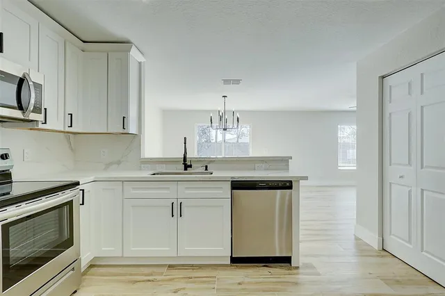 a kitchen with stainless steel appliances granite countertop a sink and stove top oven