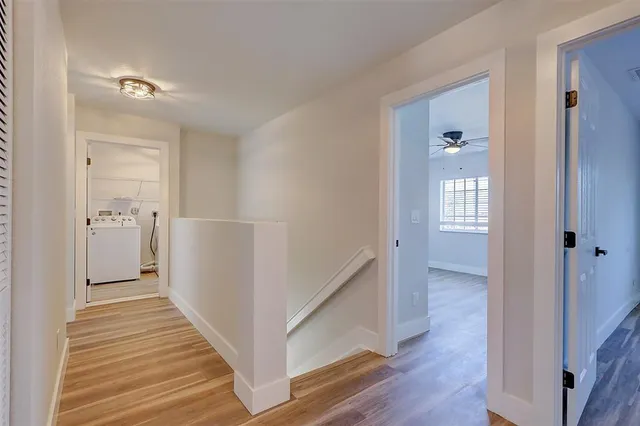 a view of a hallway with wooden floor and closet area