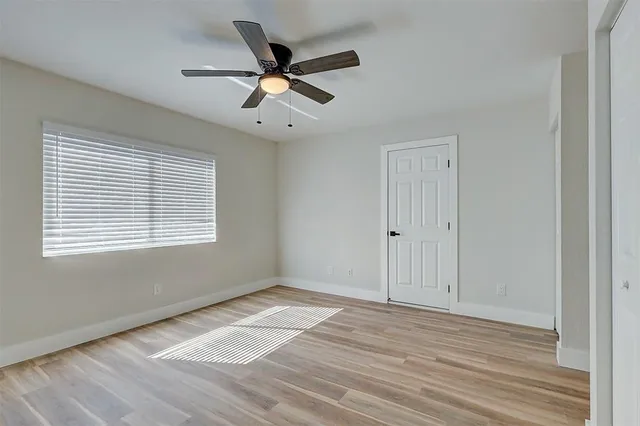 a view of a big room with wooden floor and windows