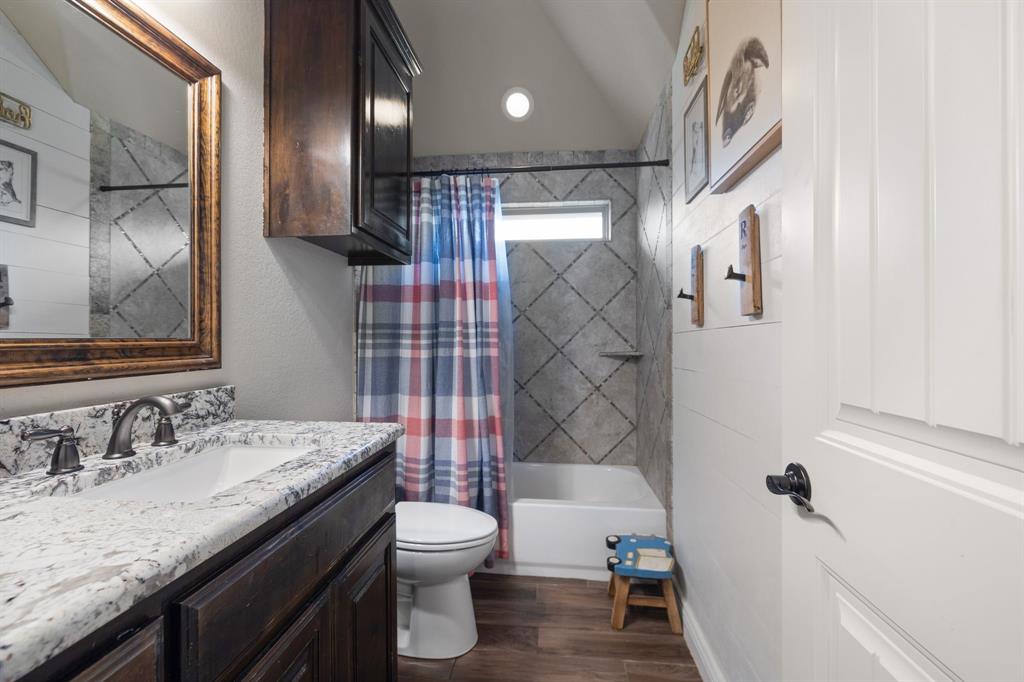 2103 Cash Point Court Granbury, TX 76049 - Photo 22 of 38 a bathroom with a granite countertop sink toilet and shower