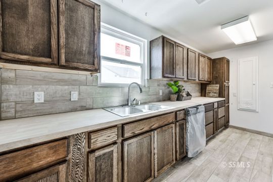 329 North Balsam Street Ridgecrest, CA 93555 - Photo 18 of 27 a kitchen with a sink stove and cabinets
