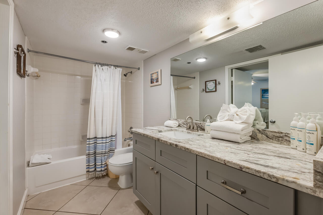 1114 Santa Rosa Boulevard, Unit 208 Fort Walton Beach, FL 32548 - Photo 20 of 73 a bathroom with a granite countertop sink a toilet and shower