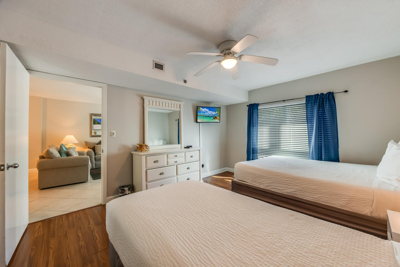 1114 Santa Rosa Boulevard, Unit 208 Fort Walton Beach, FL 32548 - Photo 24 of 73 a bedroom with a large bed and wooden floor