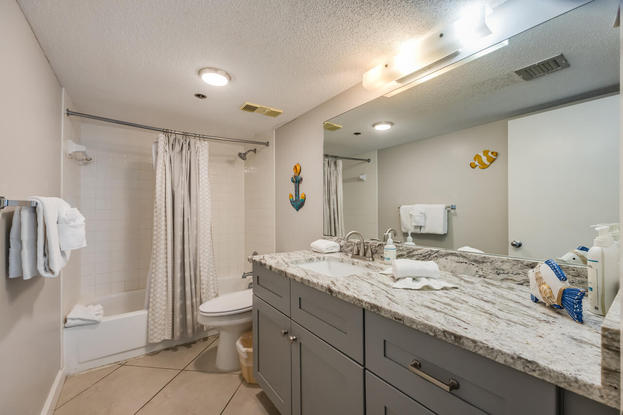 1114 Santa Rosa Boulevard, Unit 208 Fort Walton Beach, FL 32548 - Photo 25 of 73 a spacious bathroom with a granite countertop sink a toilet and a shower