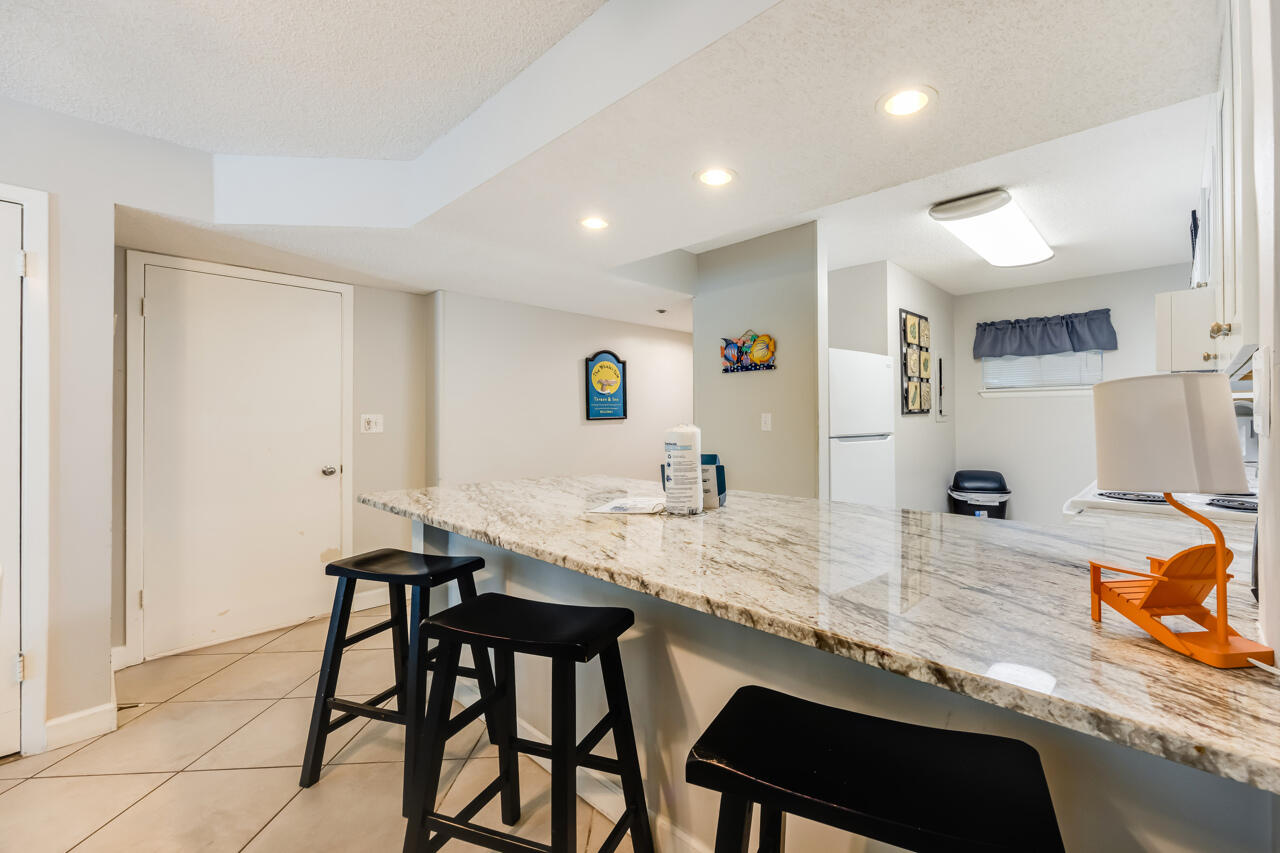 1114 Santa Rosa Boulevard, Unit 208 Fort Walton Beach, FL 32548 - Photo 4 of 73 a kitchen with stainless steel appliances granite countertop a table chairs sink and cabinets