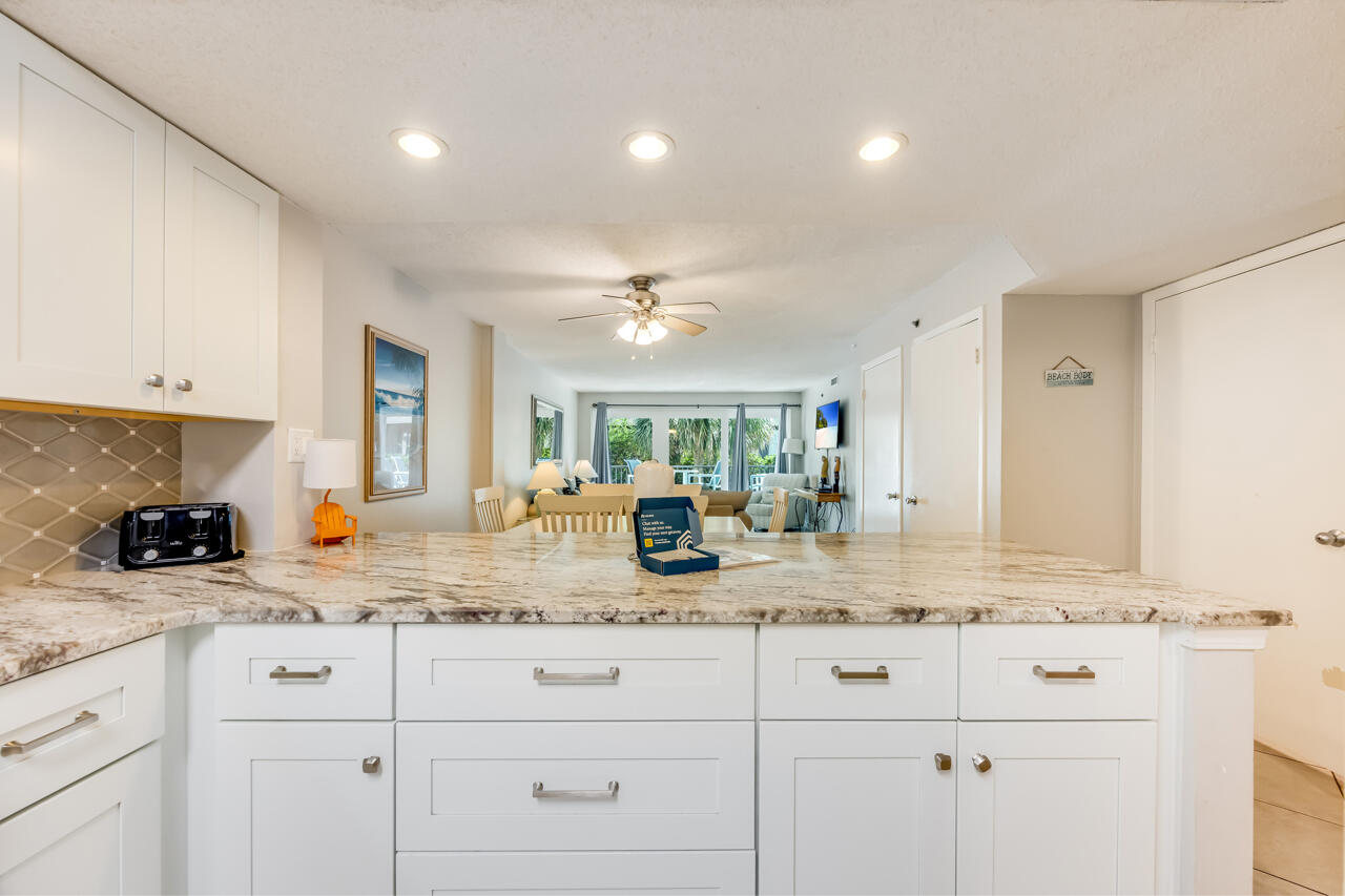 1114 Santa Rosa Boulevard, Unit 208 Fort Walton Beach, FL 32548 - Photo 8 of 73 a kitchen with white cabinets and chandelier