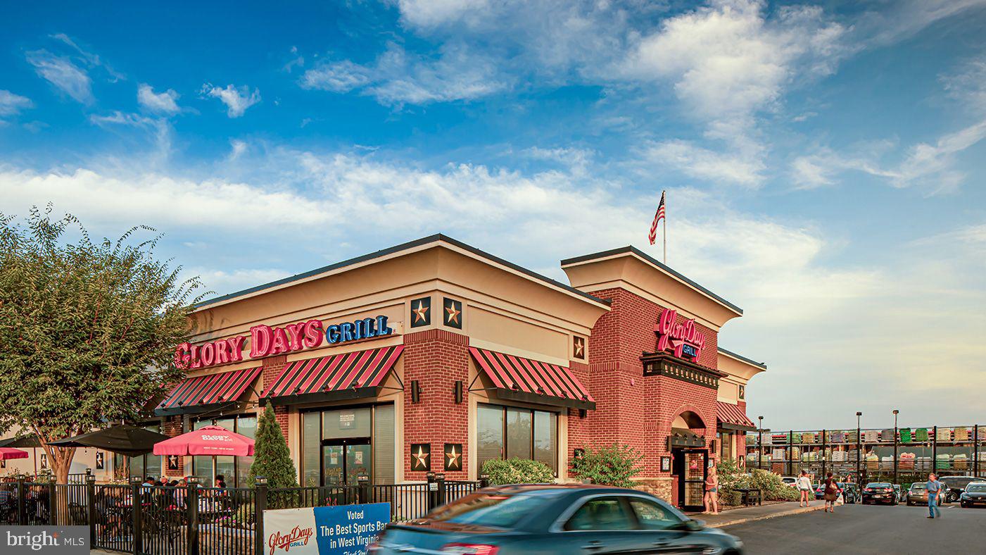 360 Anthem Street, Unit 445 Ranson, WV 25438 - Photo 46 of 87 a front view of a building with retail shops car parked and city street