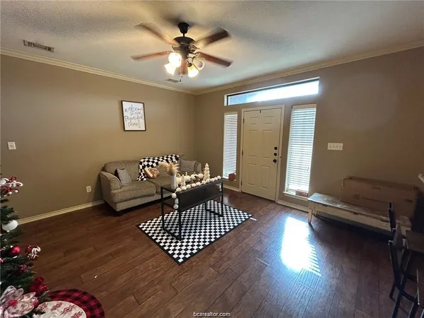 a living room with furniture and a wooden floor