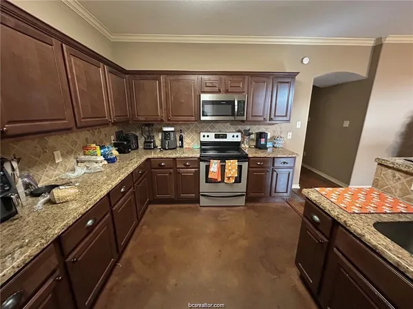 a kitchen with stainless steel appliances granite countertop a stove a sink dishwasher and a refrigerator