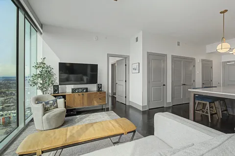 a living room with furniture wooden floor and kitchen view
