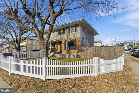 a view of a house with a small yard and wooden fence