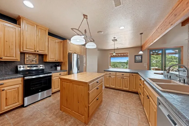 a kitchen with a sink stove top oven and refrigerator