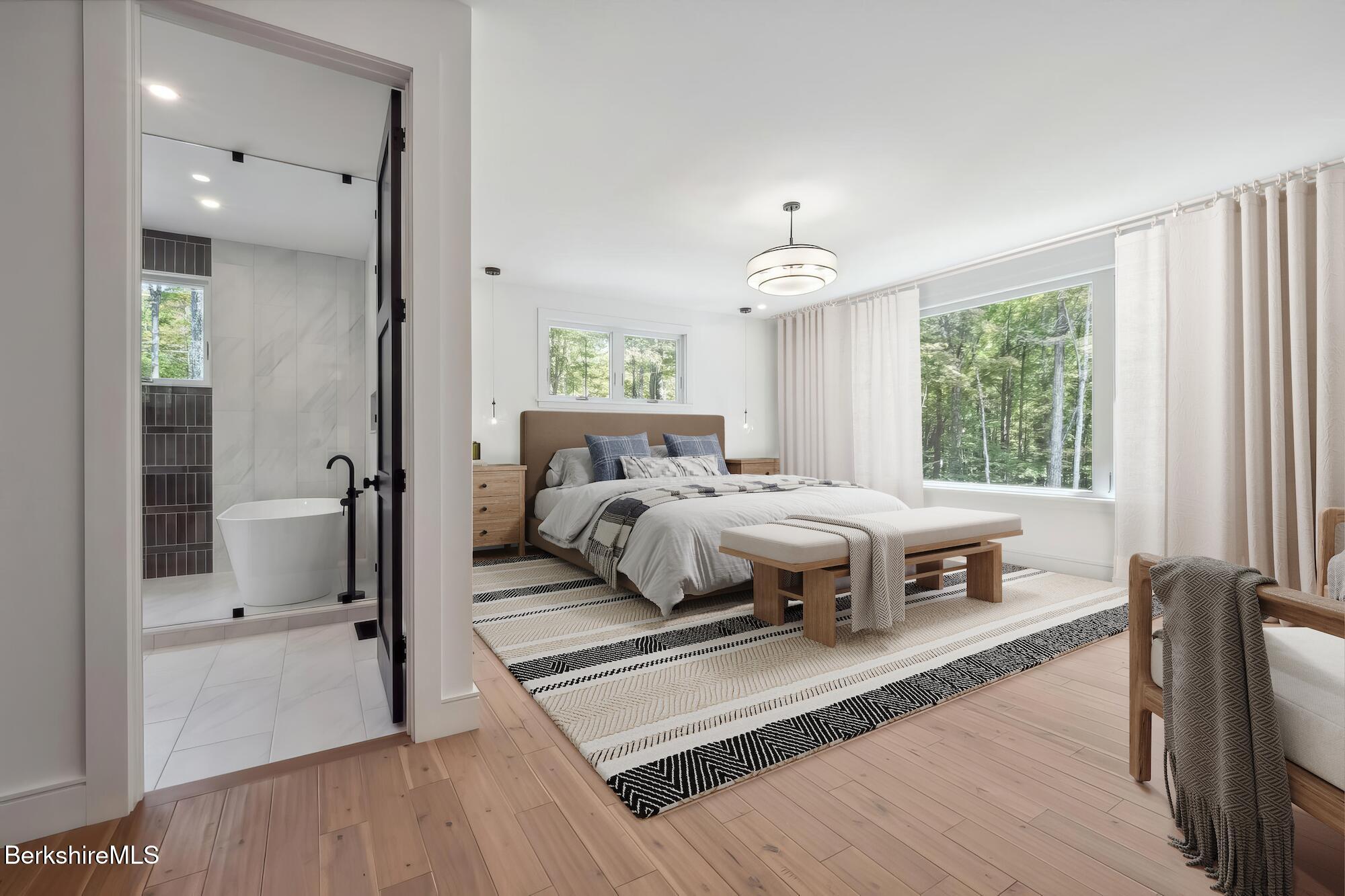 112 Tyringham Road Monterey, MA 01245 - Photo 21 of 57 a bedroom with a bed wooden floor and a large window