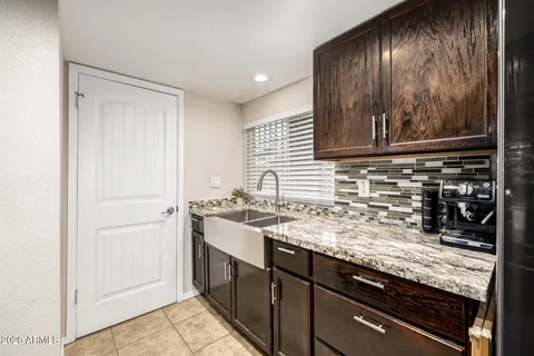 a kitchen with kitchen island granite countertop a sink stove and cabinets