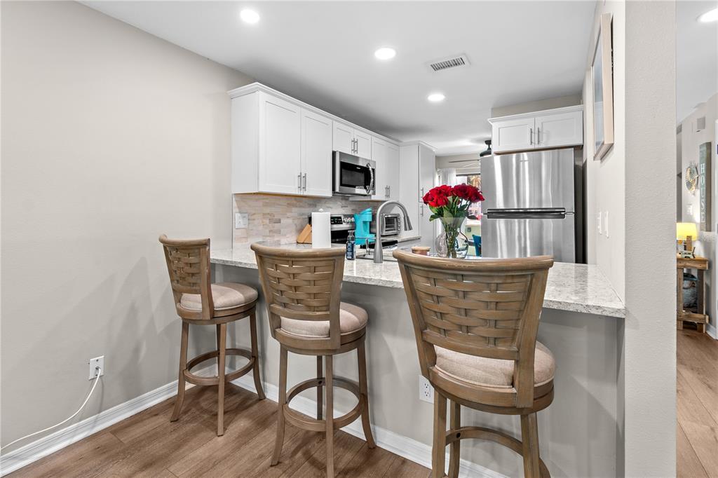 1752 Stickney Point Road, Unit 102 Sarasota, FL 34231 - Photo 11 of 50 a view of a dining room with furniture wooden floor and kitchen view