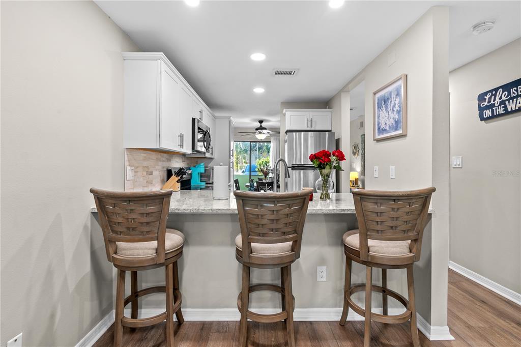 1752 Stickney Point Road, Unit 102 Sarasota, FL 34231 - Photo 12 of 50 a view of livingroom and dining room with furniture wooden floor and a potted plant