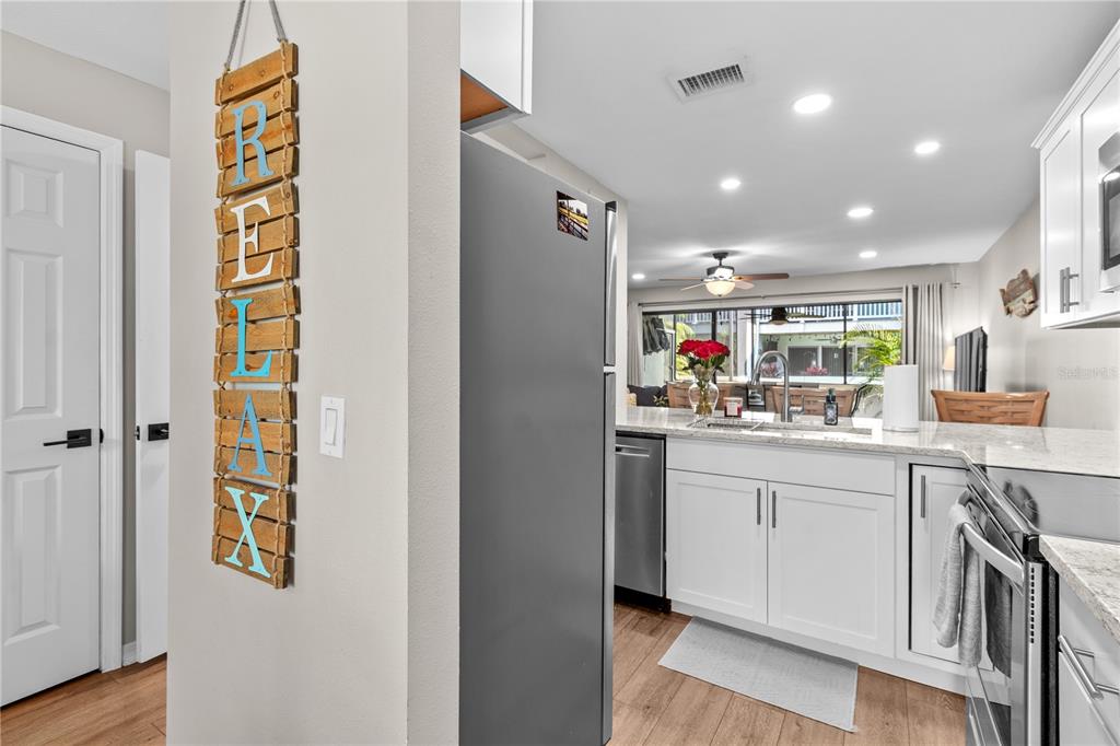 1752 Stickney Point Road, Unit 102 Sarasota, FL 34231 - Photo 16 of 50 a kitchen with stainless steel appliances granite countertop a refrigerator and a sink