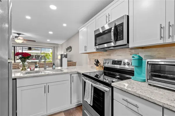 a kitchen with stainless steel appliances granite countertop a sink and a stove