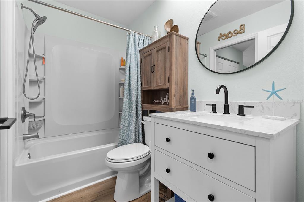 1752 Stickney Point Road, Unit 102 Sarasota, FL 34231 - Photo 33 of 50 a bathroom with a sink a toilet and a mirror