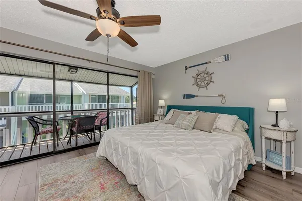 a bedroom with a large bed and a flat tv screen on dresser
