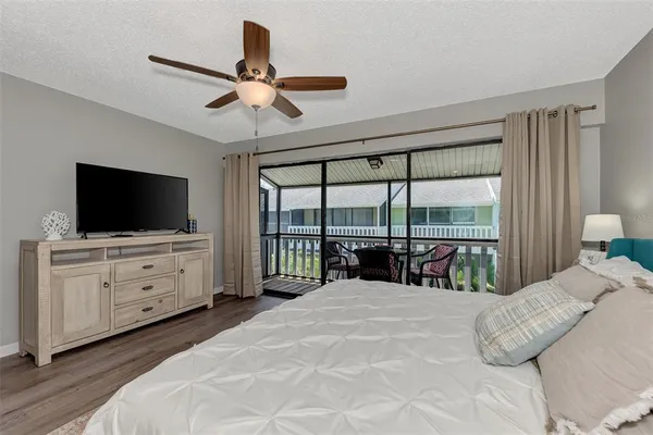 a bedroom with a large bed and a flat tv screen on dresser