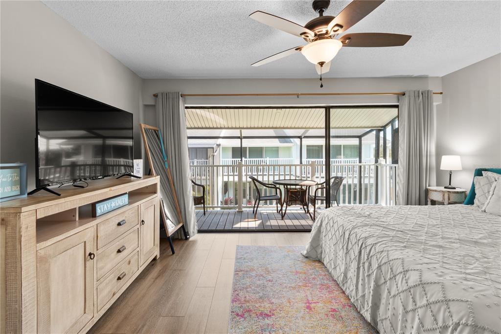 1752 Stickney Point Road, Unit 102 Sarasota, FL 34231 - Photo 39 of 50 a bedroom with a large bed and a flat tv screen on dresser