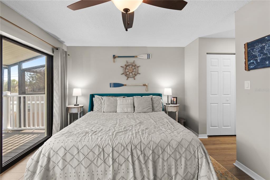 1752 Stickney Point Road, Unit 102 Sarasota, FL 34231 - Photo 40 of 50 a bedroom with a large bed and a chandelier