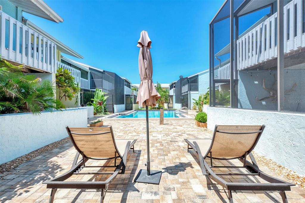 1752 Stickney Point Road, Unit 102 Sarasota, FL 34231 - Photo 48 of 50 a view of an chairs and tables in the patio