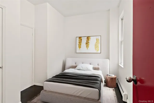 a bedroom with a bed and painting on the wall