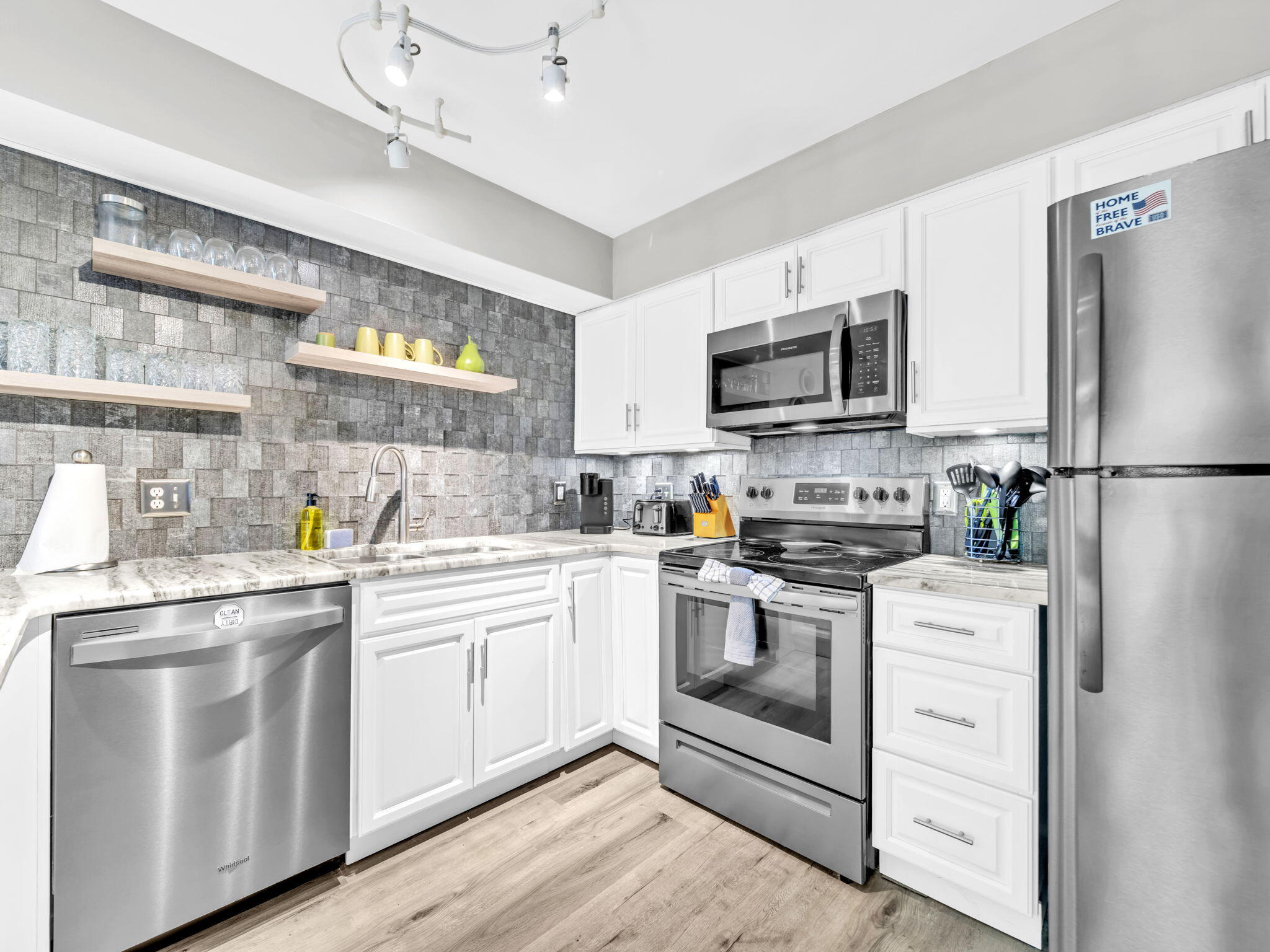 a kitchen with white cabinets and stainless steel appliances