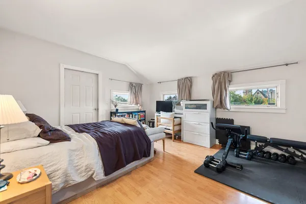 a bedroom with a bed a large window and chair