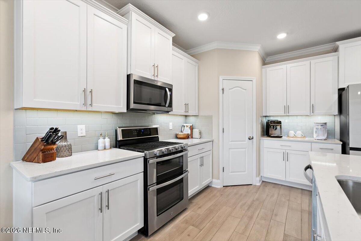 15 Zancara Street St. Augustine, FL 32084 - Photo 9 of 46 a kitchen with white cabinets stainless steel appliances and sink