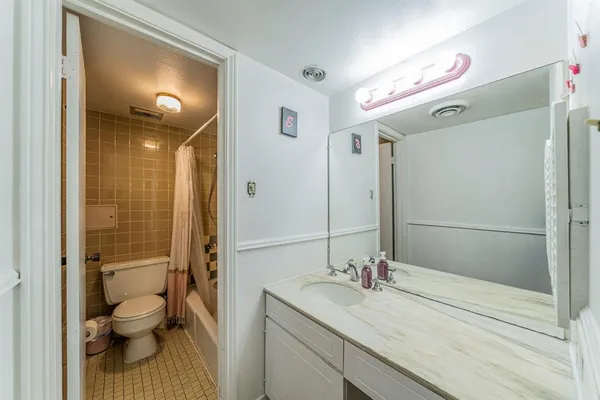 a bathroom with a granite countertop sink toilet a shower and a mirror