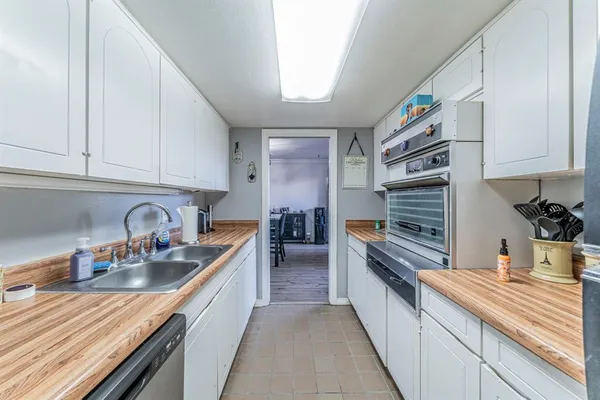 a kitchen with stainless steel appliances granite countertop a sink stove and cabinets