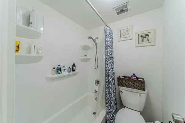 a white toilet sitting next to a bath tub